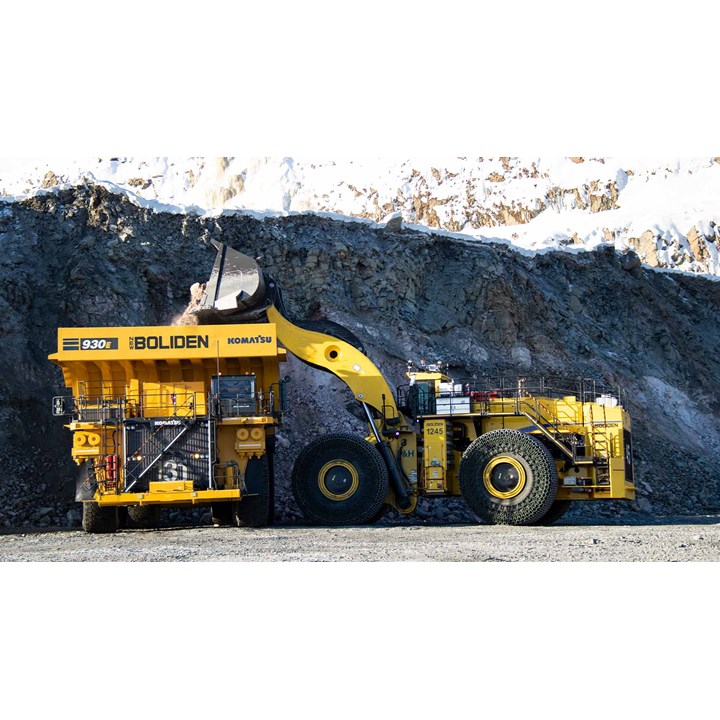 Yellow mining dump truck and excavator at a rocky excavation site.